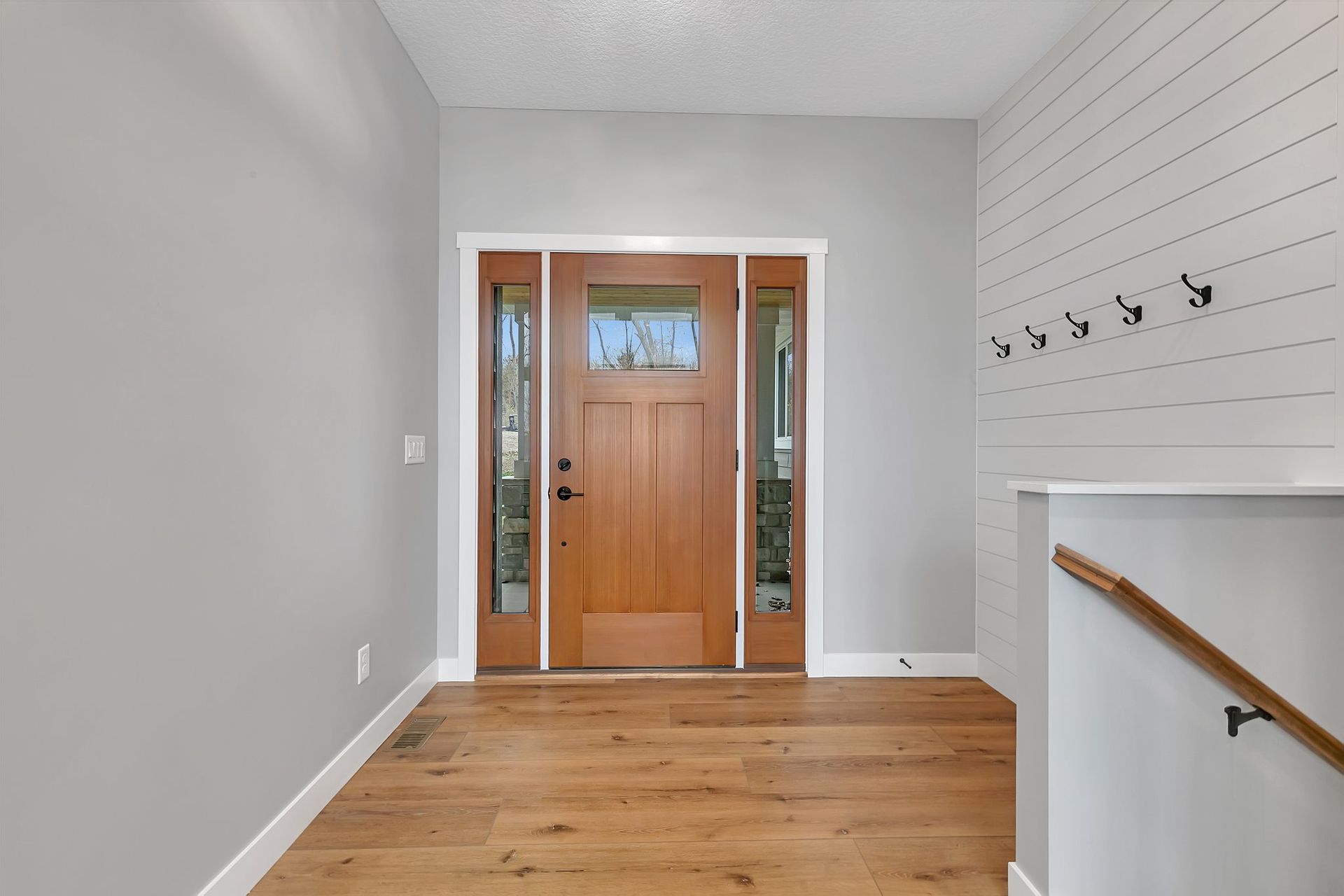 A hallway with a wooden door and stairs