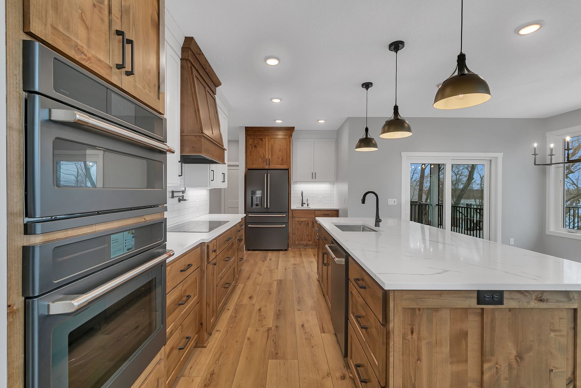 A kitchen with wooden cabinets , stainless steel appliances , and a large island.