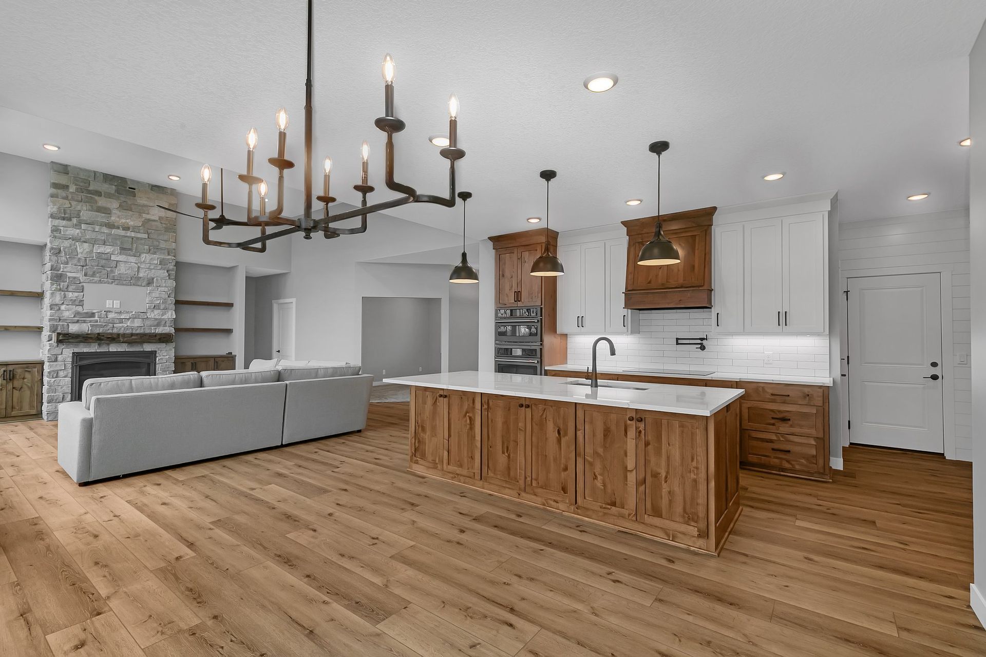 A kitchen with a large island and a chandelier hanging from the ceiling.
