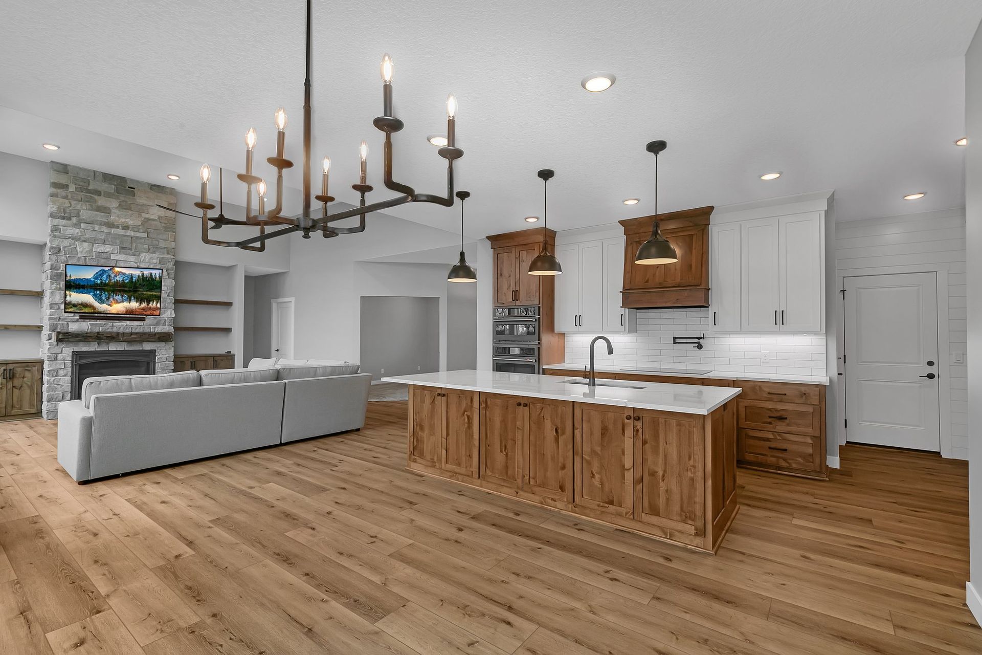 A kitchen with a large island and a chandelier hanging from the ceiling.