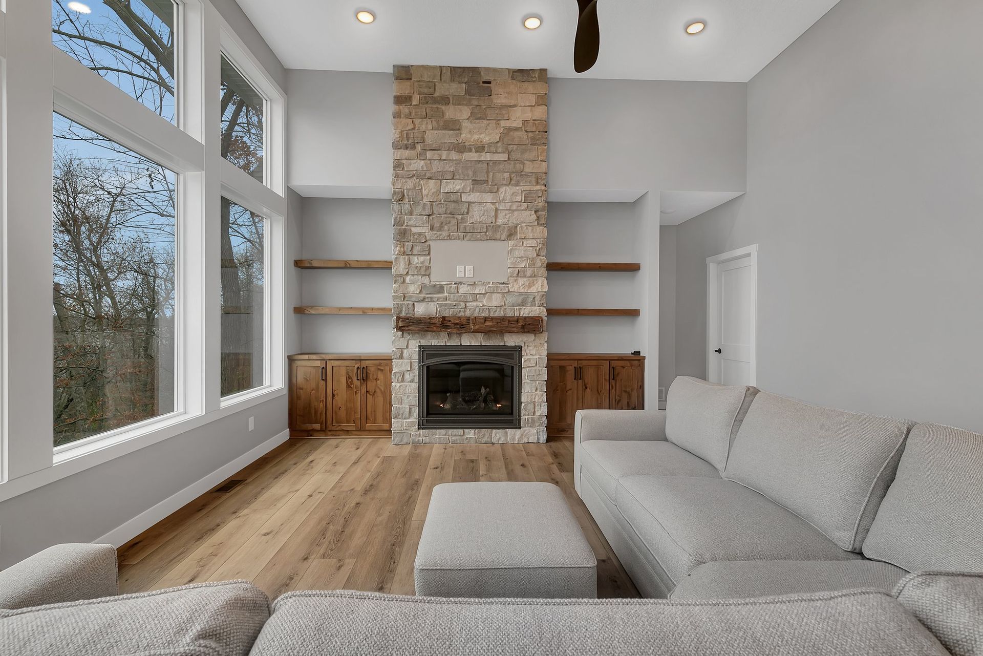 A living room with a stone fireplace and a couch.