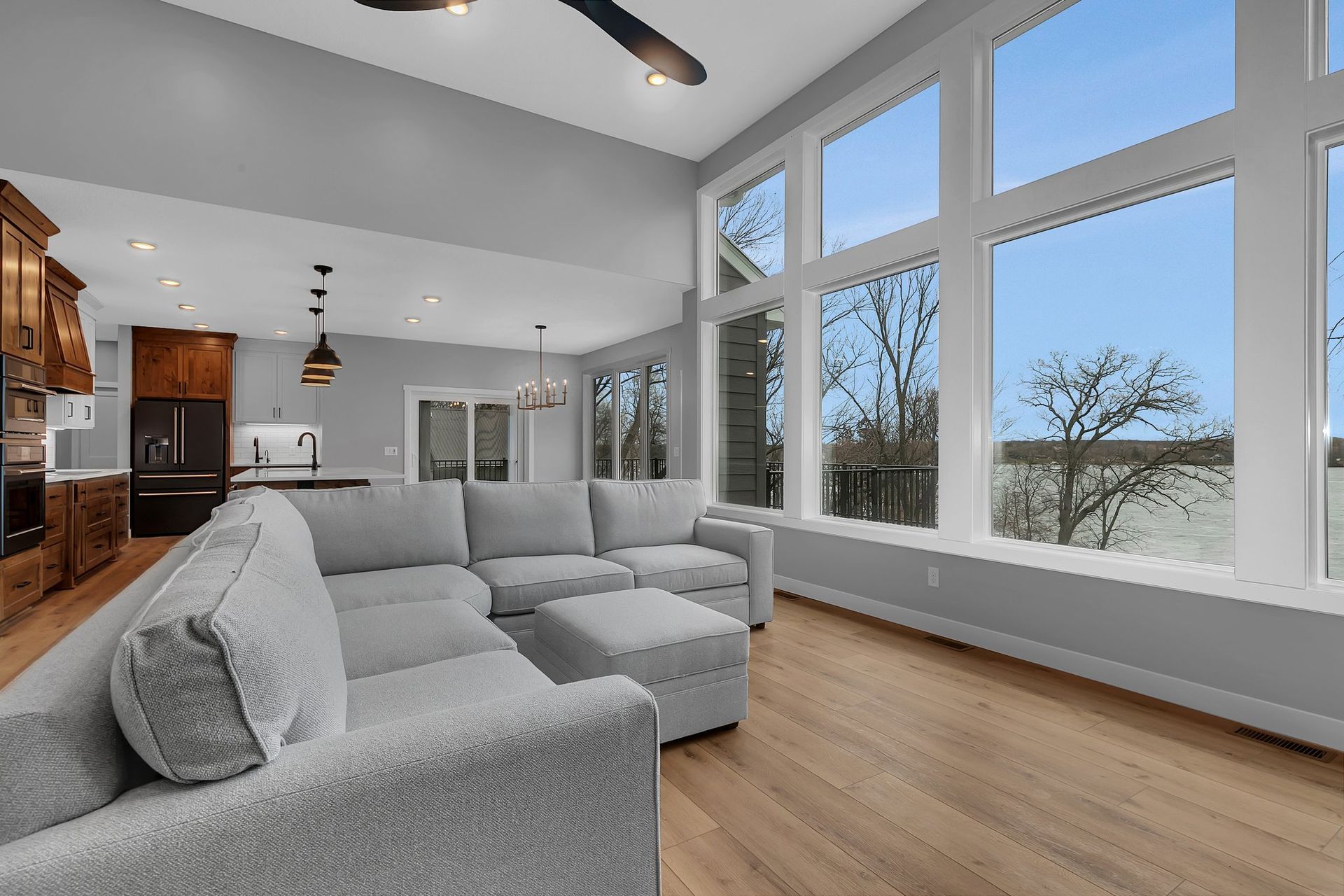 A living room with a large sectional couch and a lot of windows.