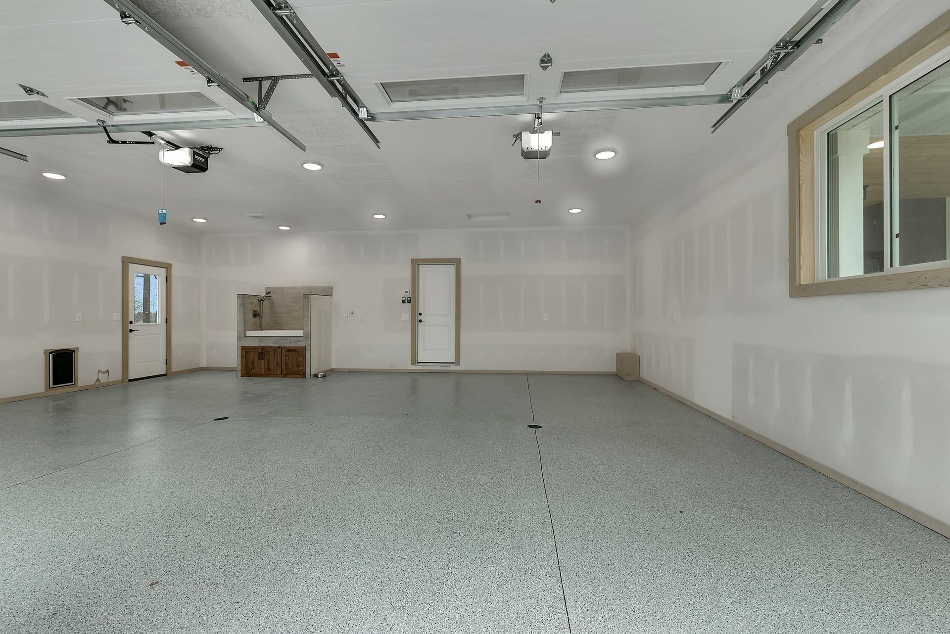 An empty garage with a gray floor and white walls