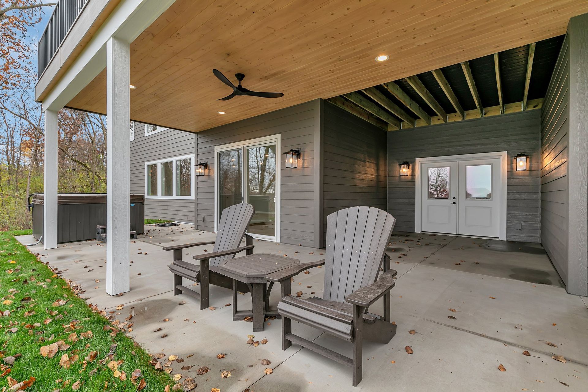 A patio with chairs and a table under a ceiling fan.