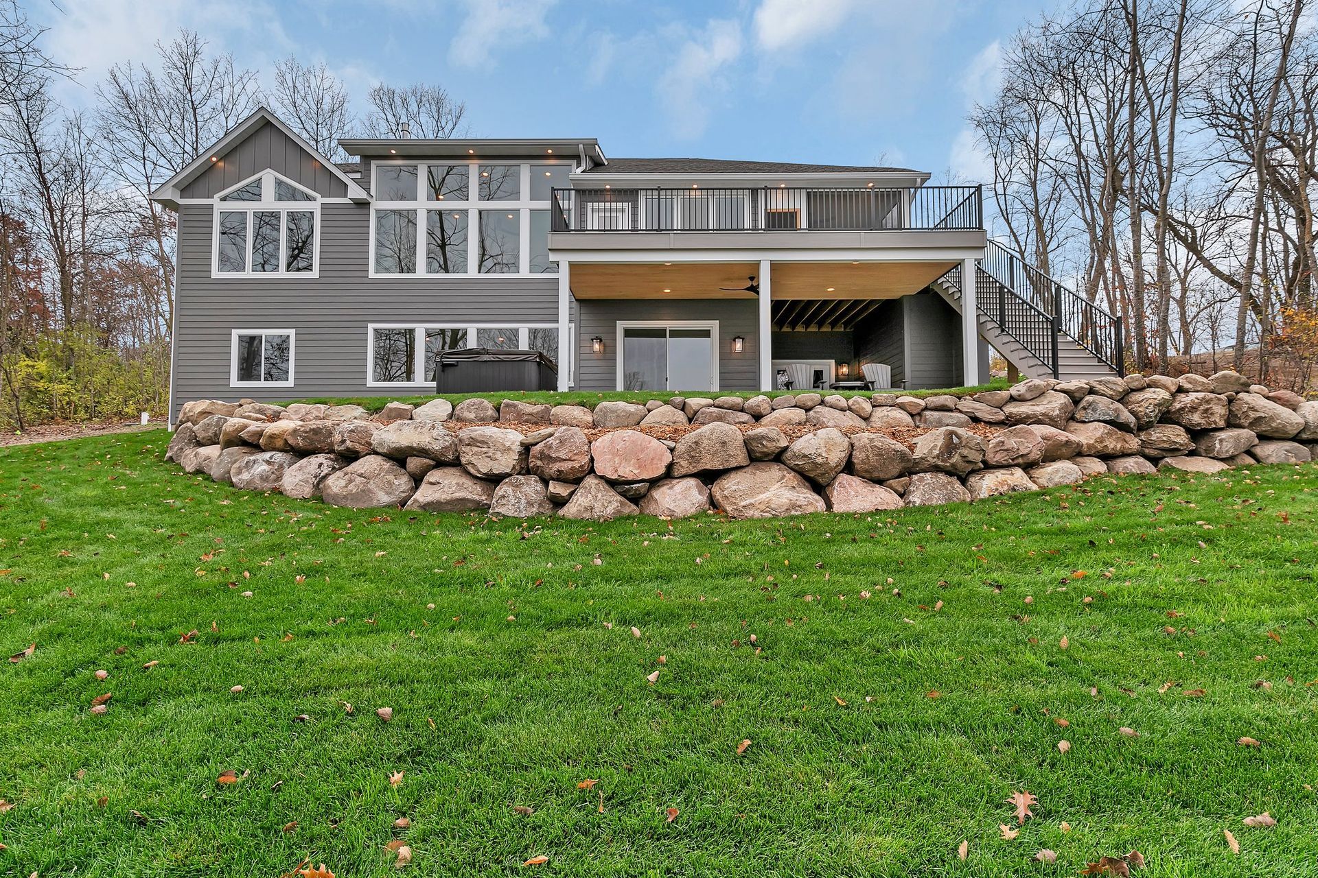 A large house is sitting on top of a lush green hill.