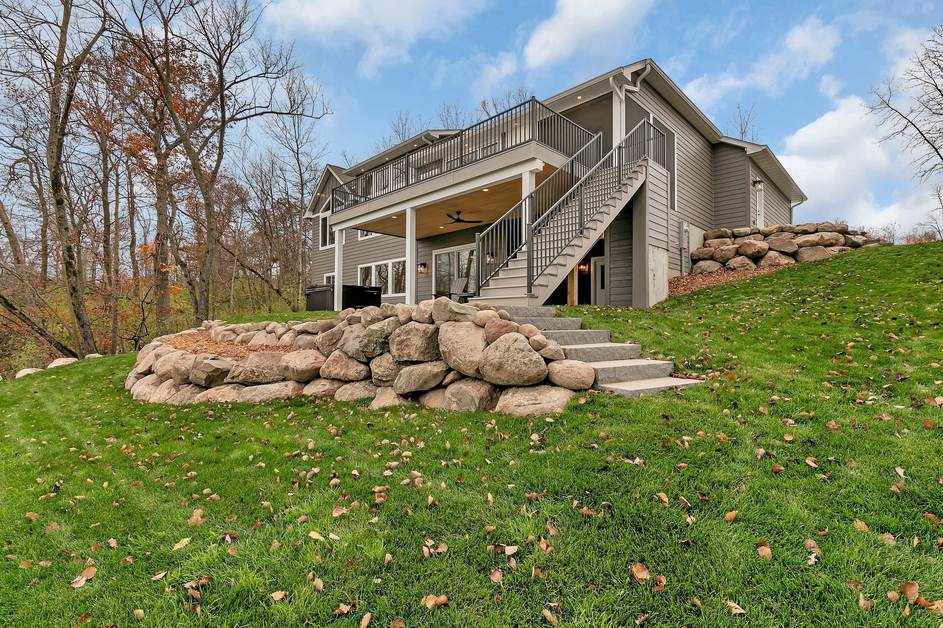 A large house is sitting on top of a lush green hill.