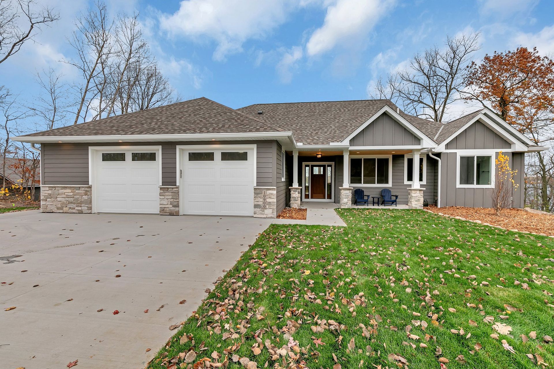 A large house with two garages and a large lawn in front of it.