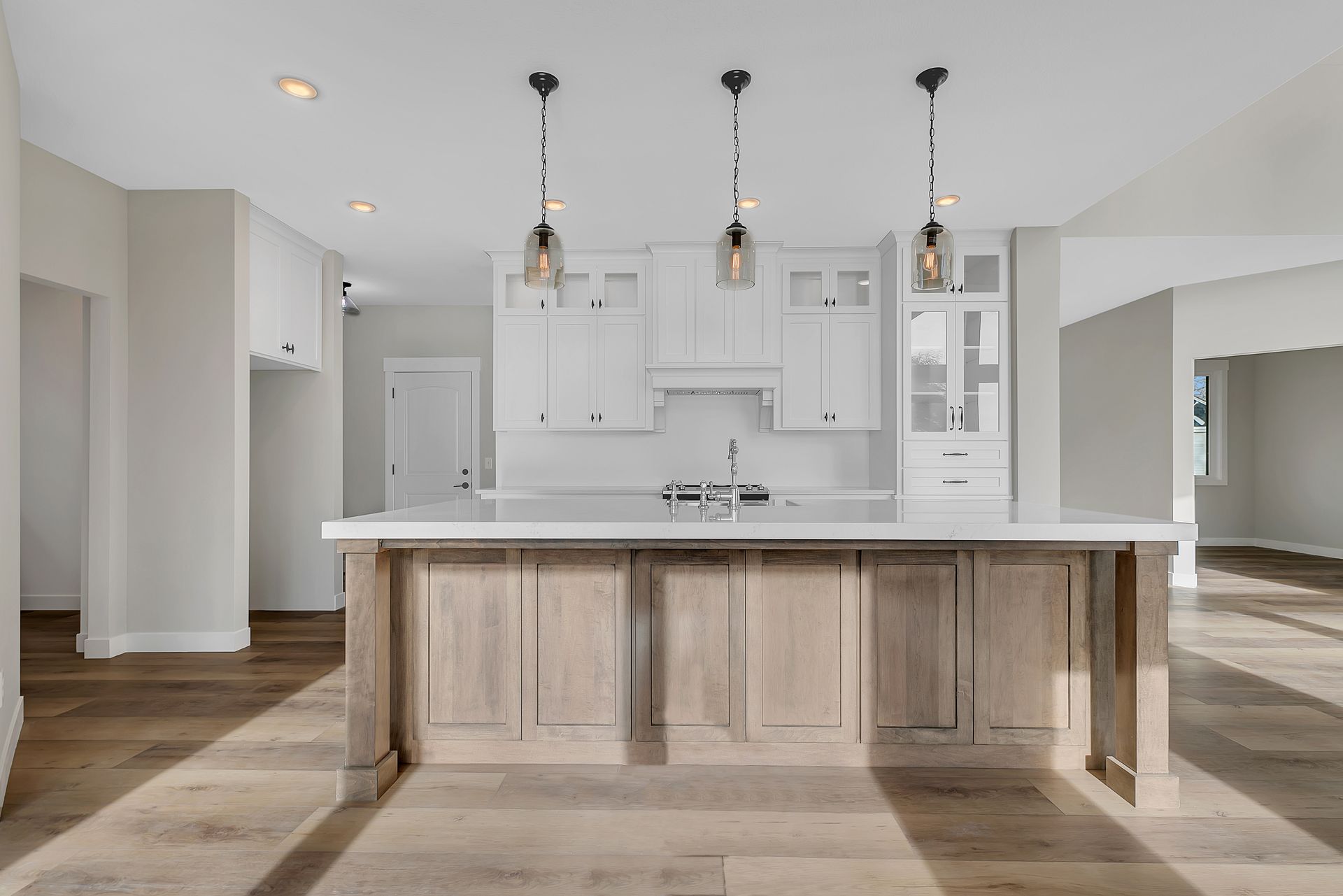 A kitchen with a large island and white cabinets.