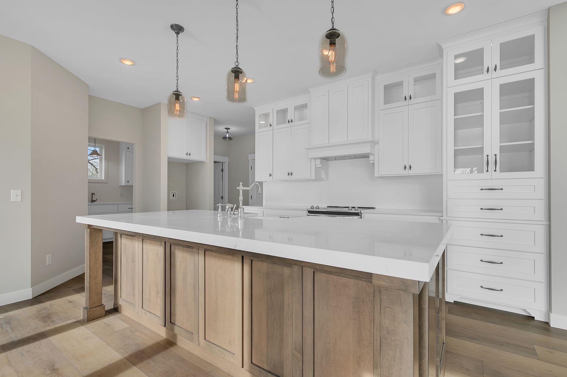 A kitchen with white cabinets and a large island.