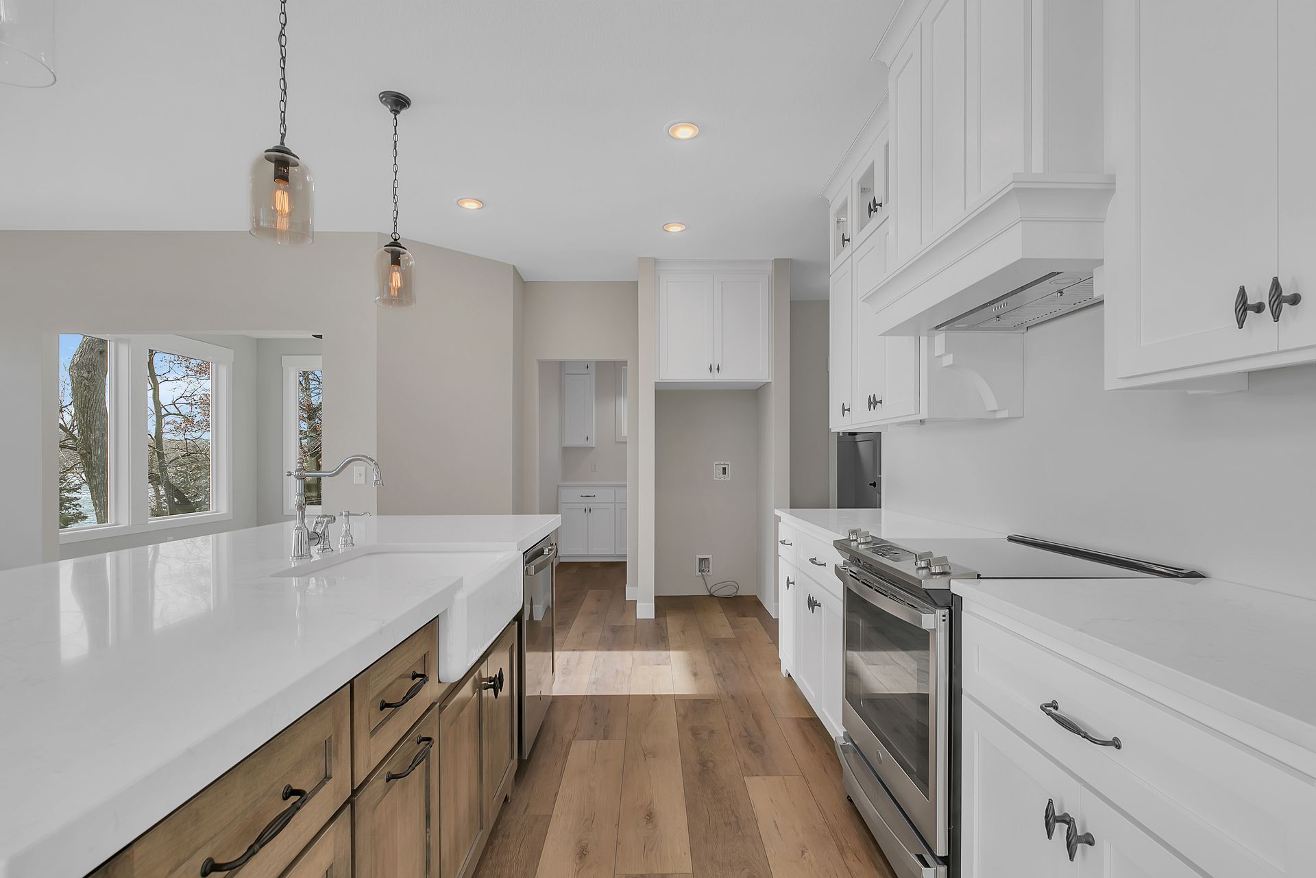 A kitchen with white cabinets , stainless steel appliances , and hardwood floors.