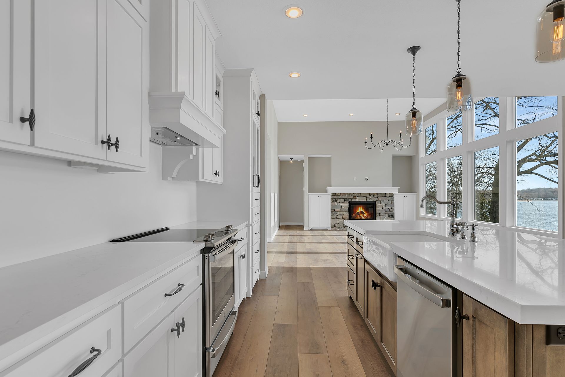 A kitchen with white cabinets , stainless steel appliances , and hardwood floors.