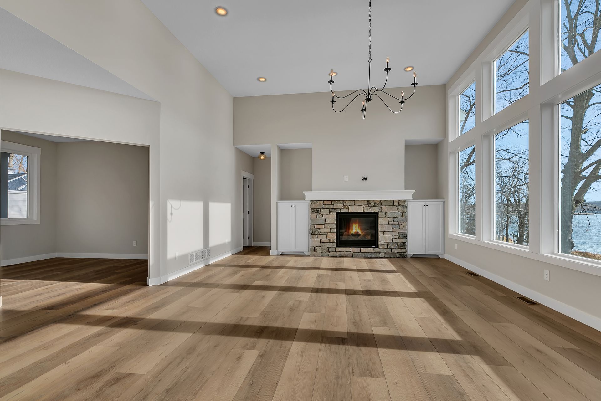An empty living room with hardwood floors and a fireplace.