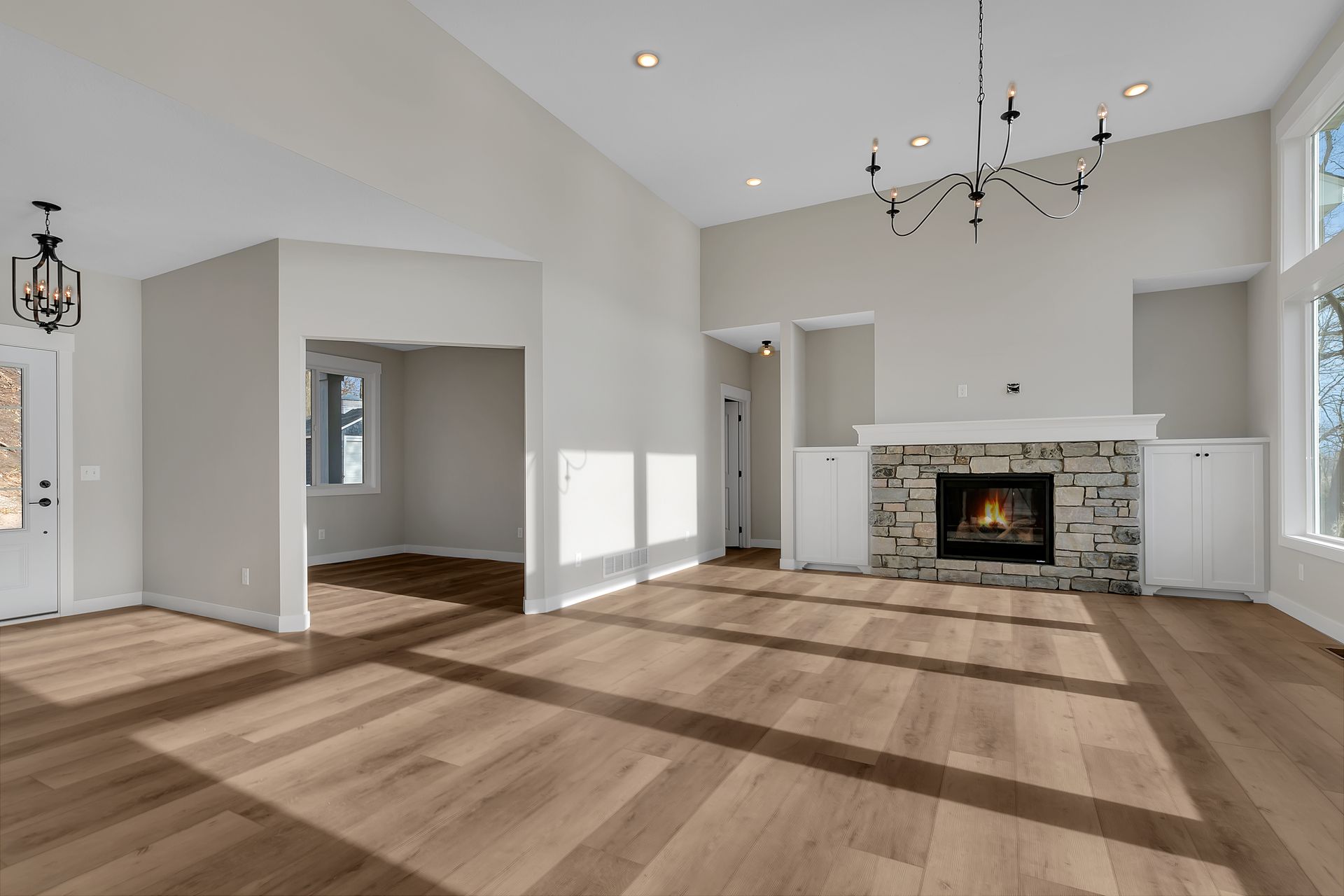 An empty living room with hardwood floors and a fireplace.