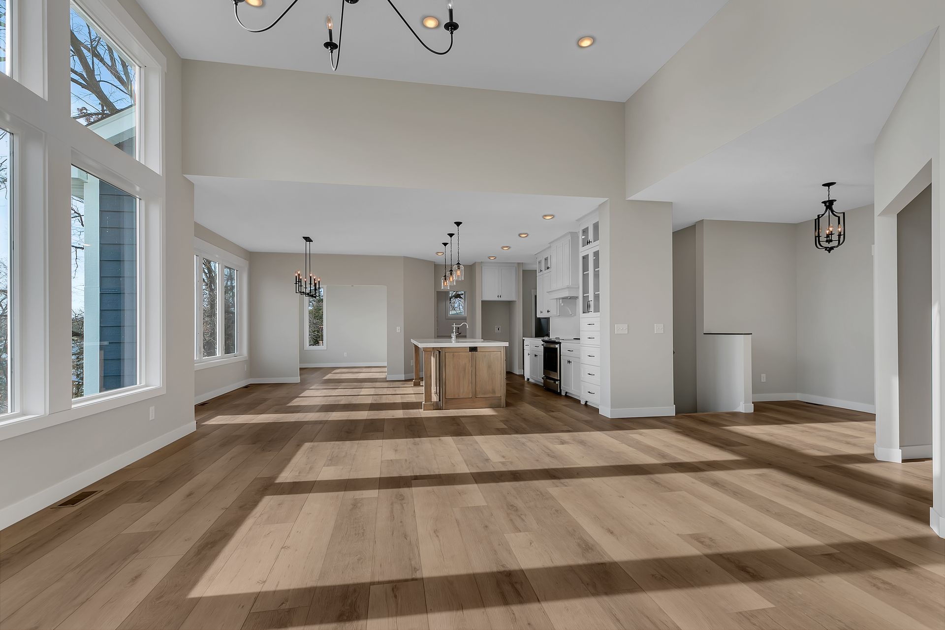 A large empty room with hardwood floors and lots of windows.