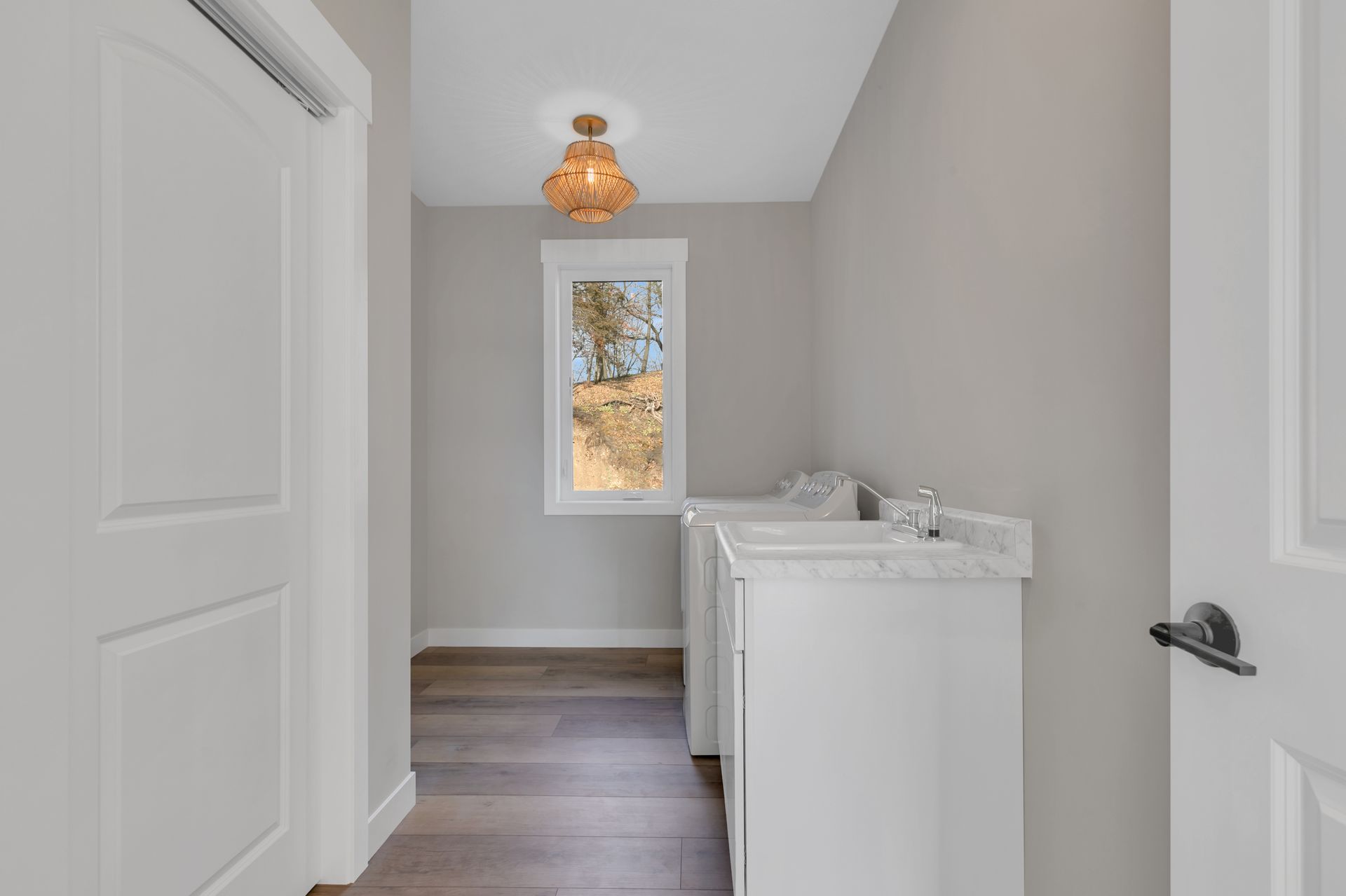A laundry room with a washer and dryer and a window.