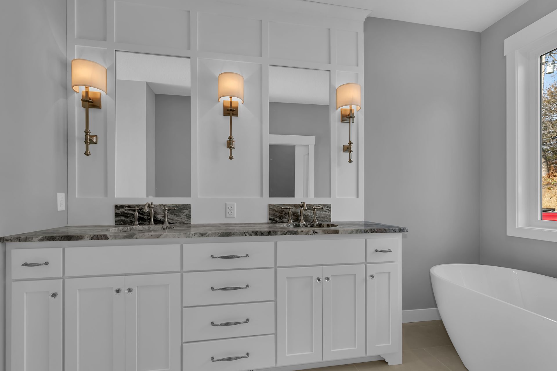 A bathroom with two sinks , two mirrors , a tub and a window.