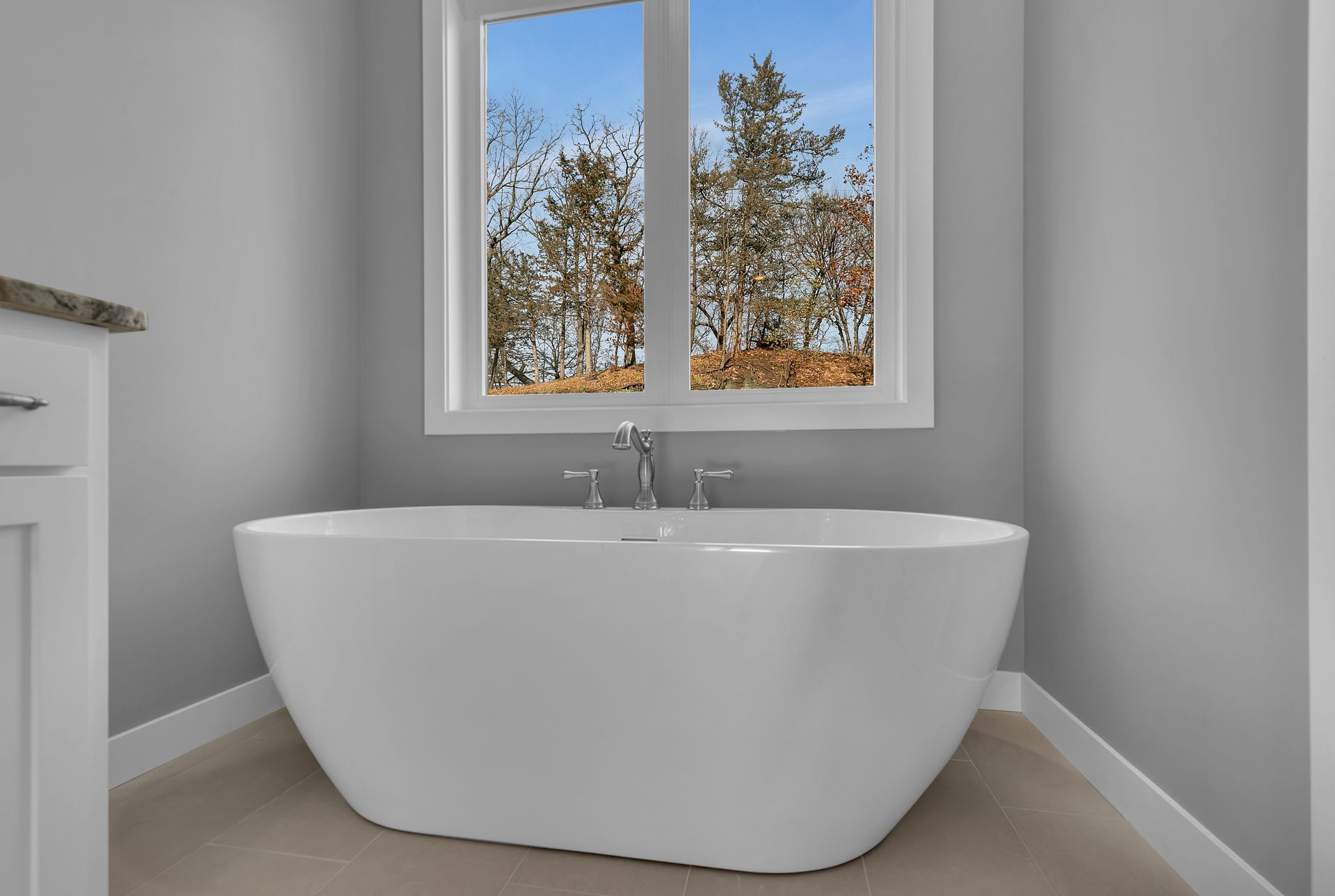 A bathroom with a bathtub and a window.