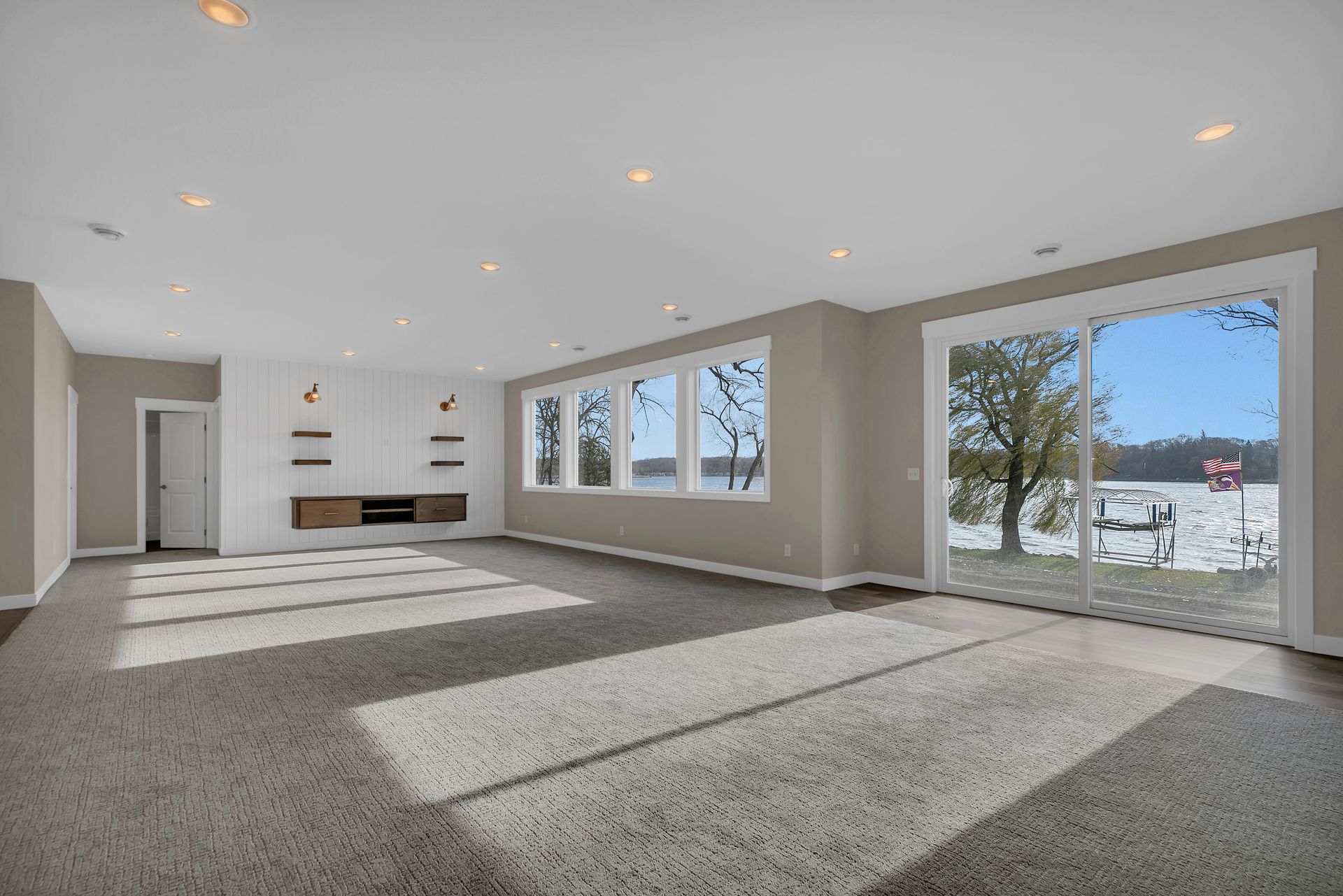 A large empty room with a lot of windows and a view of a lake.