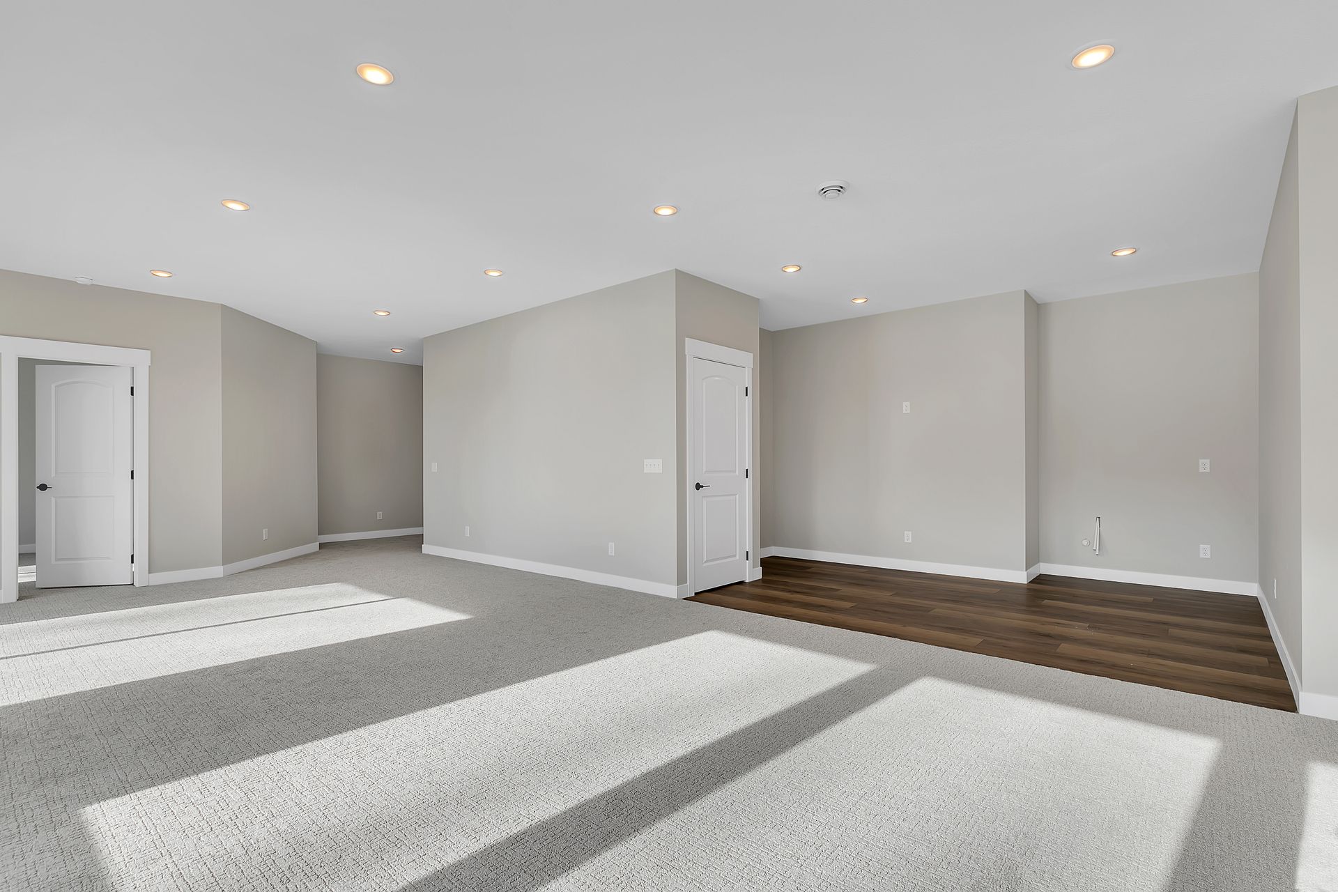 A large empty room with a carpeted floor and white walls.