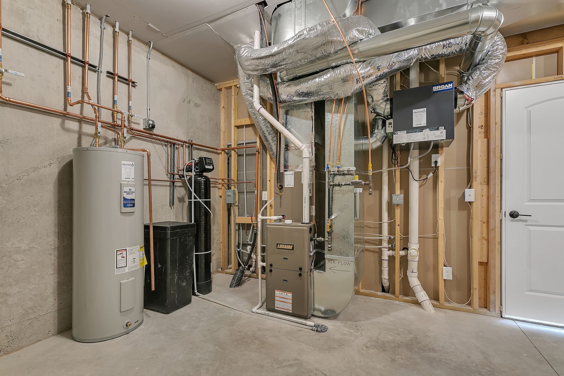 A basement with a lot of pipes and a water heater.