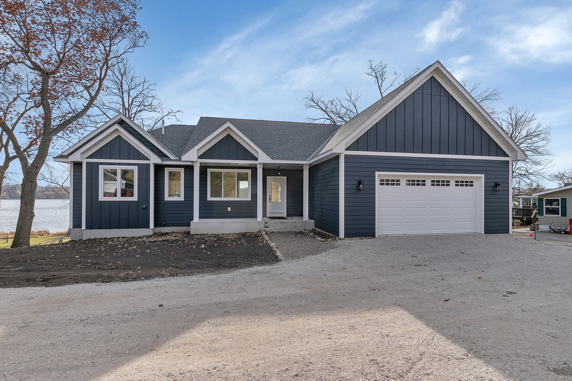 A blue house with a white garage door is for sale.