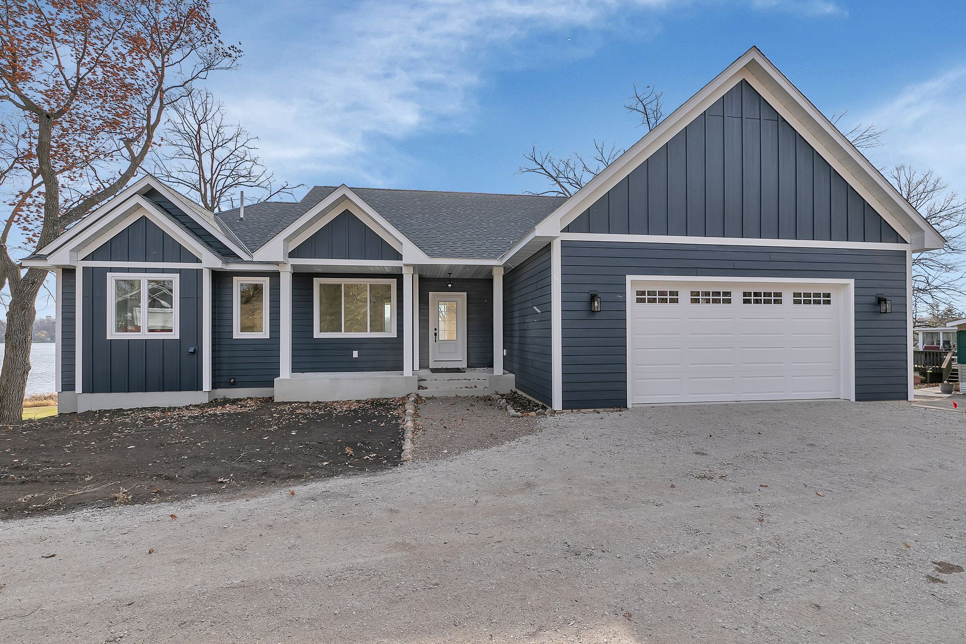 A blue house with a white garage door is for sale.