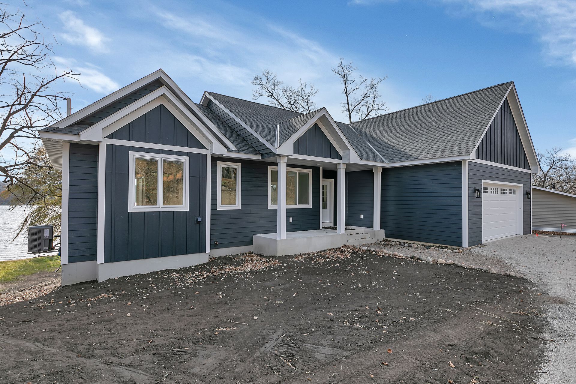 A blue and white house with a garage and a porch