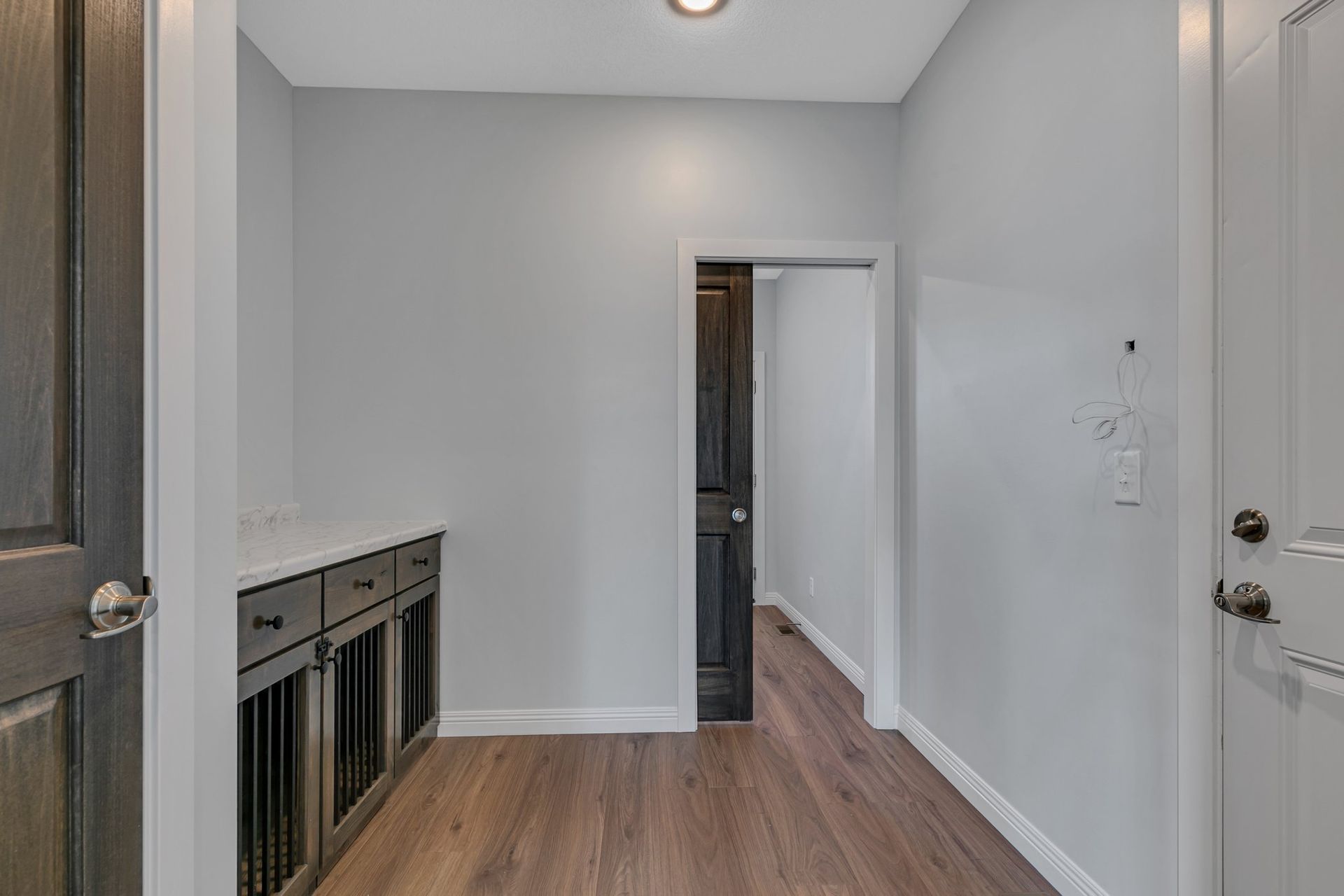 A hallway in a house with hardwood floors and a sliding door.