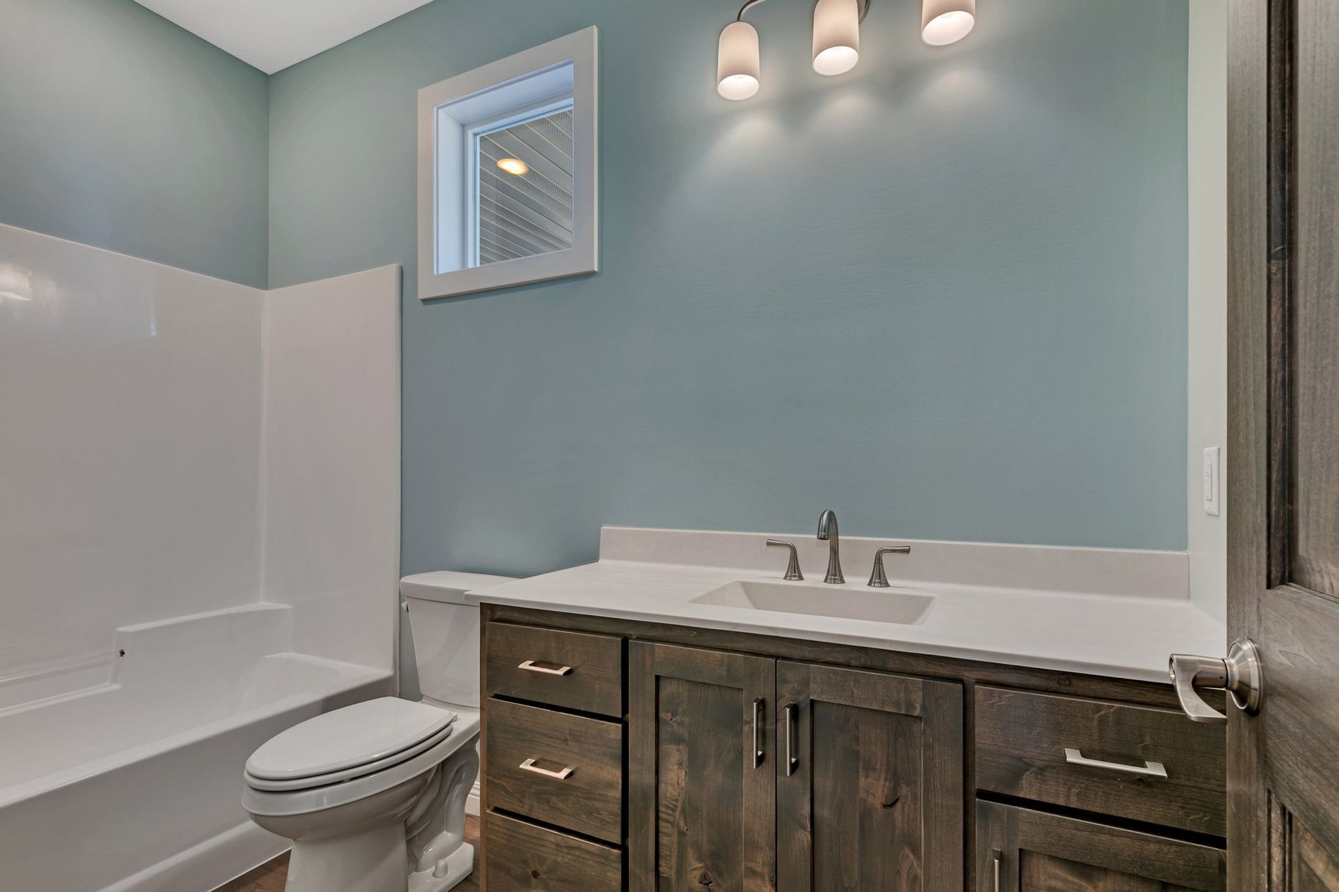 A bathroom with a toilet , sink , and bathtub.