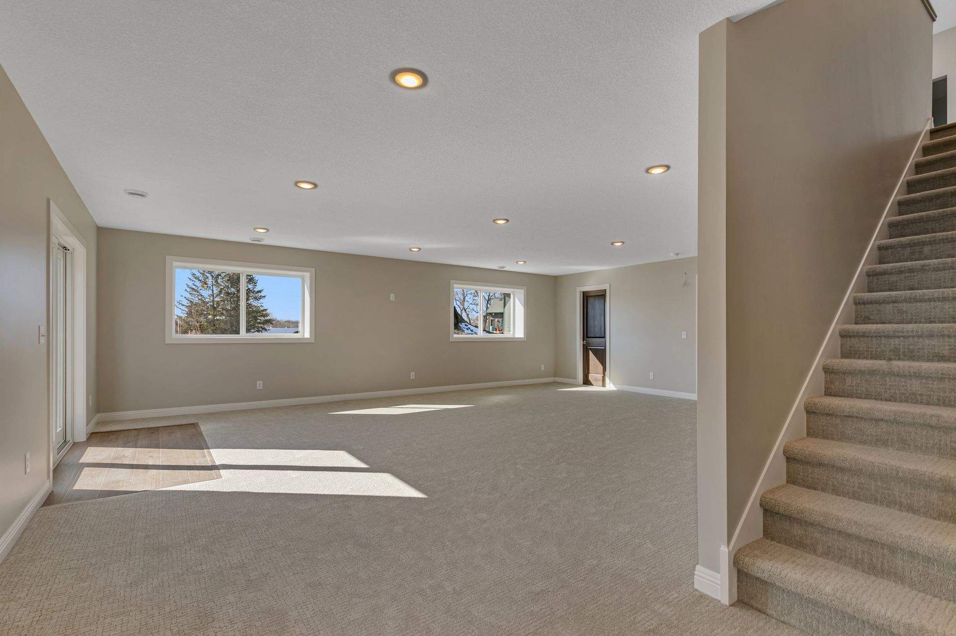An empty basement with stairs leading up to the second floor.