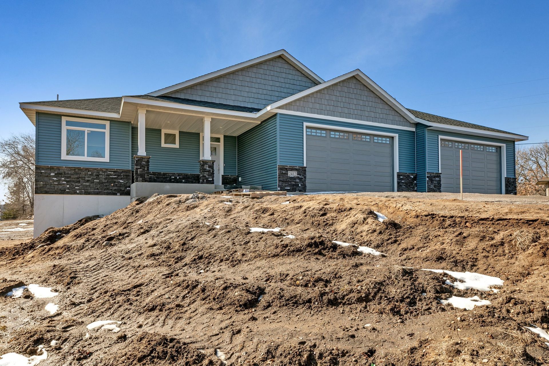 A house is sitting on top of a dirt hill.