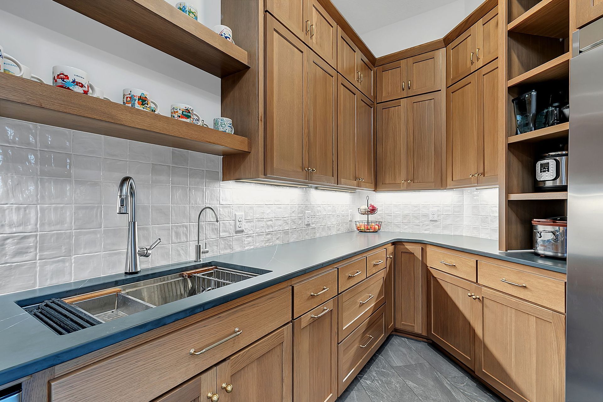 Kitchen with light wood cabinets, gray countertops, and a white tile backsplash.