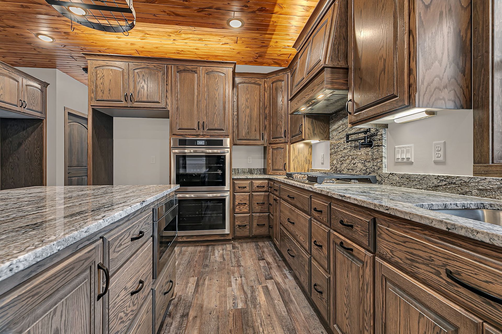 Kitchen with wood cabinets, granite countertops, and a wood ceiling.