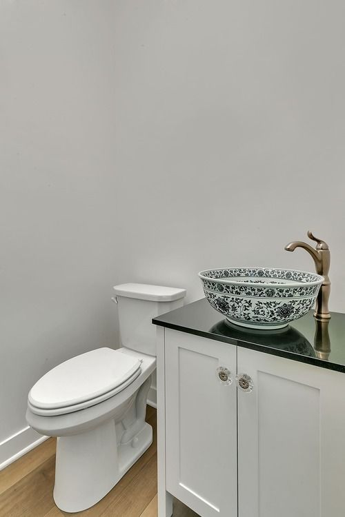 A bathroom with a toilet , sink and vanity.