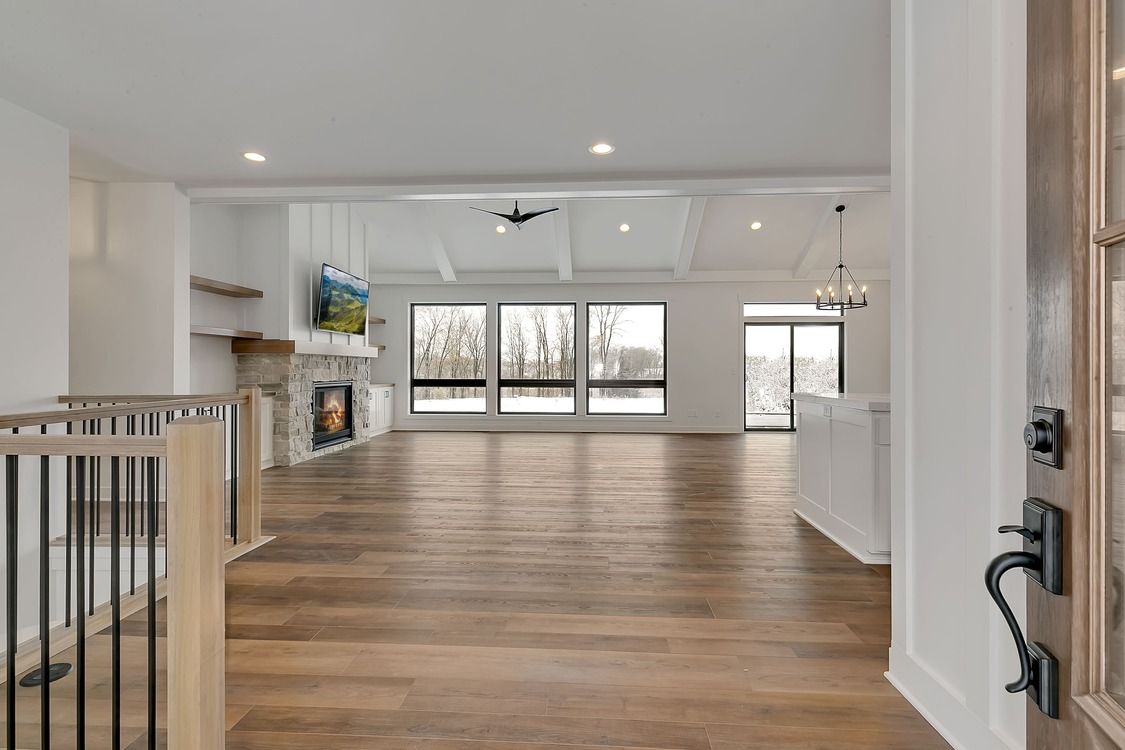 A large empty room with hardwood floors and a fireplace.