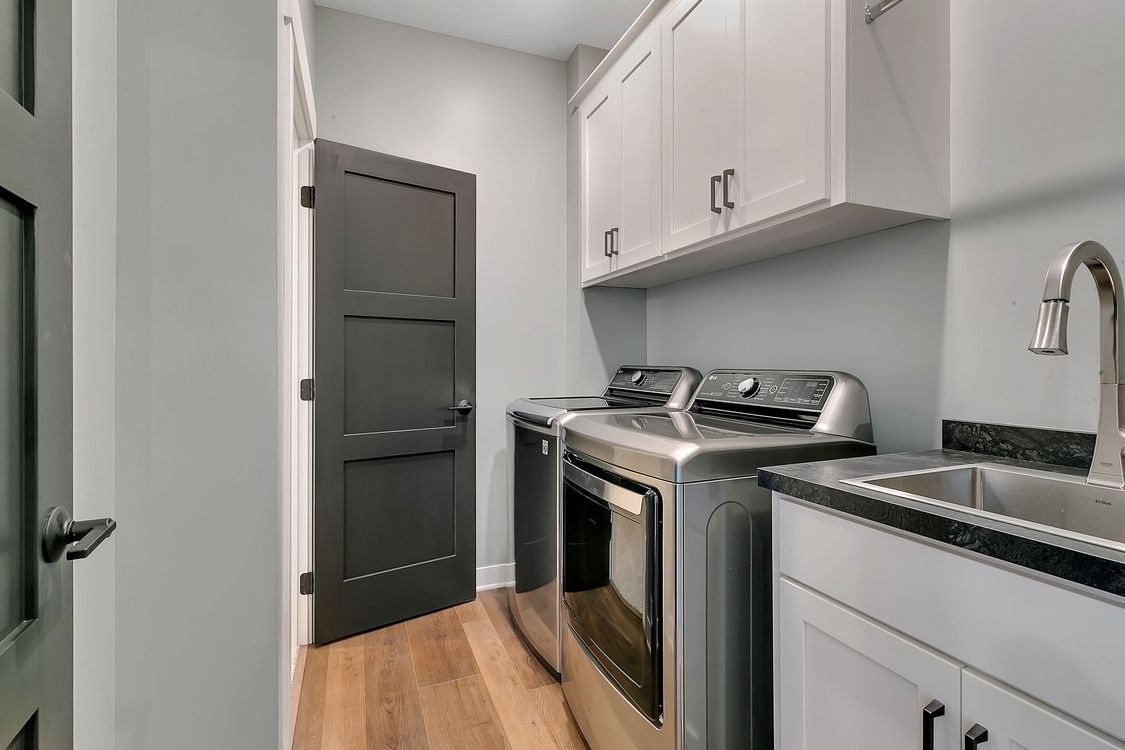 A laundry room with a washer and dryer and a sink.
