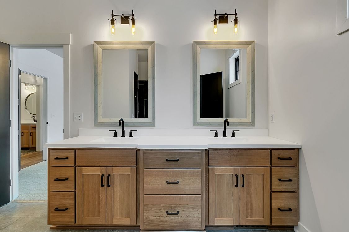 A bathroom with two sinks and two mirrors.