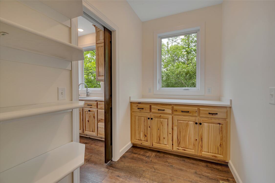 A kitchen with wooden cabinets and a window.