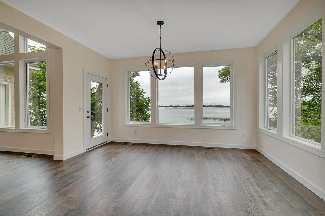 An empty room with a lot of windows and a chandelier