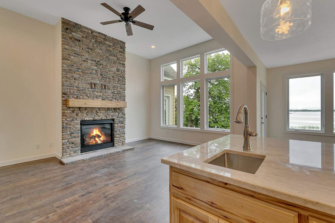 A living room with a fireplace , sink , and ceiling fan.