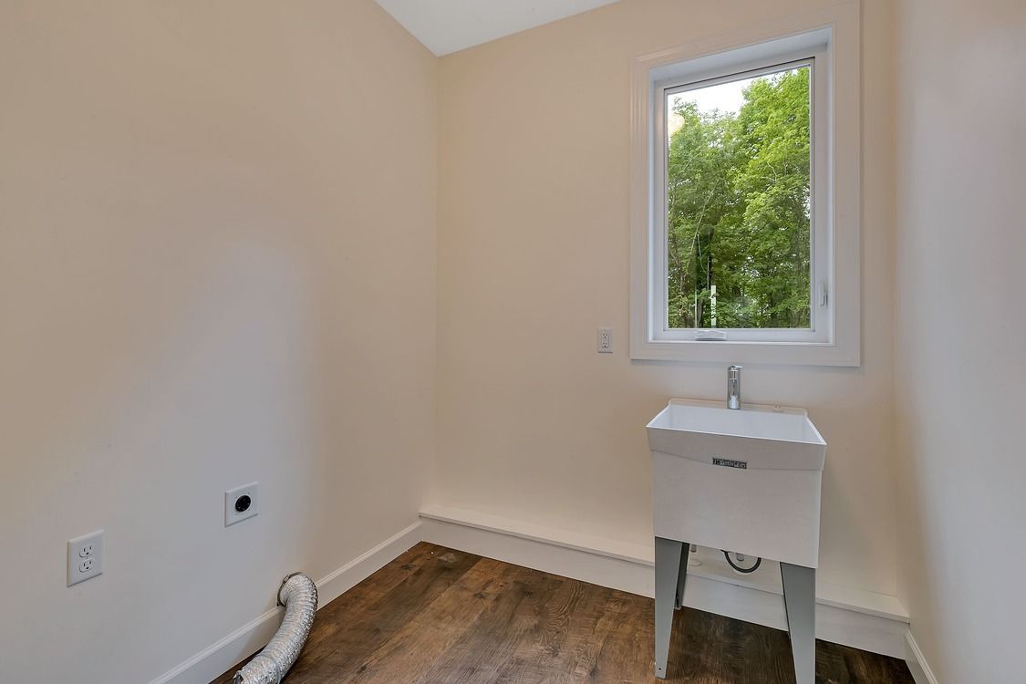 A laundry room with a sink and a window.