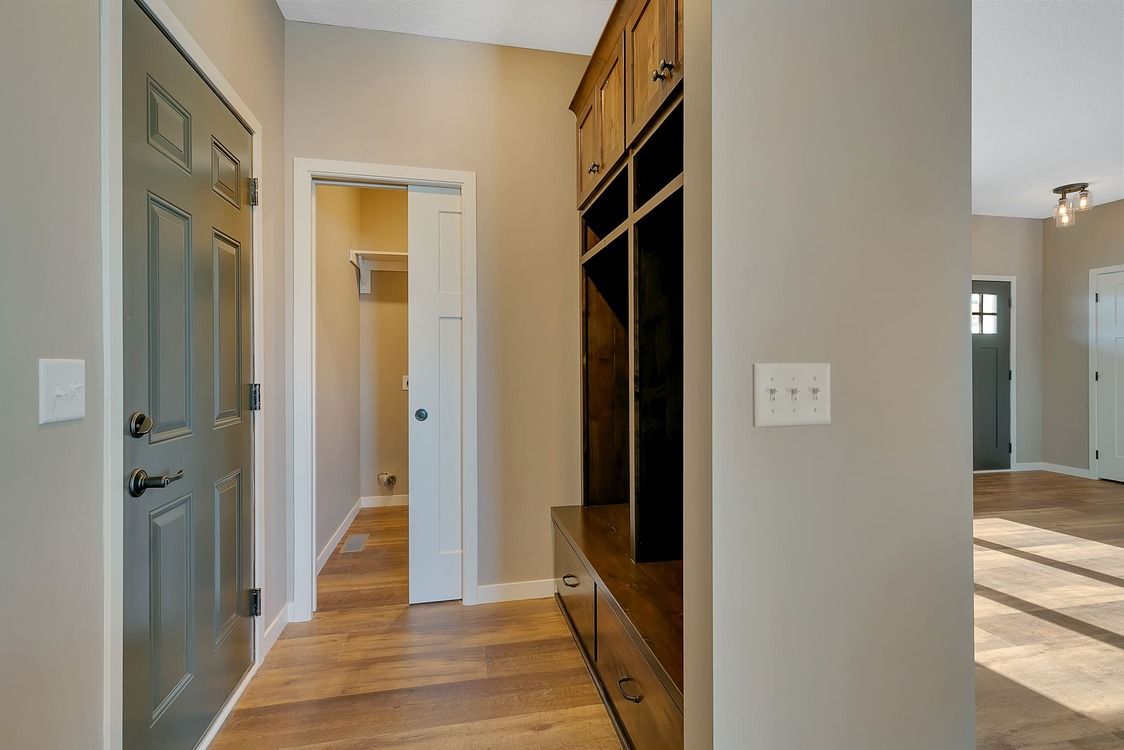A hallway in a house with wooden floors and a closet.