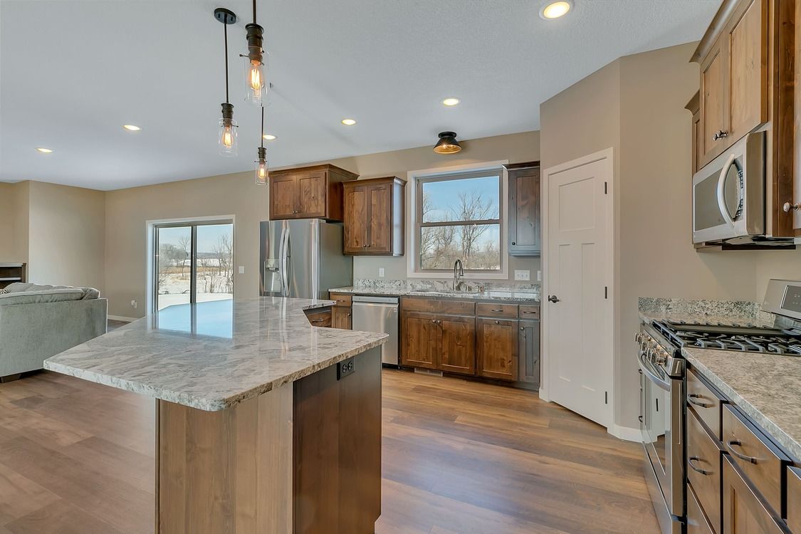 A kitchen with granite counter tops , stainless steel appliances , and wooden cabinets.