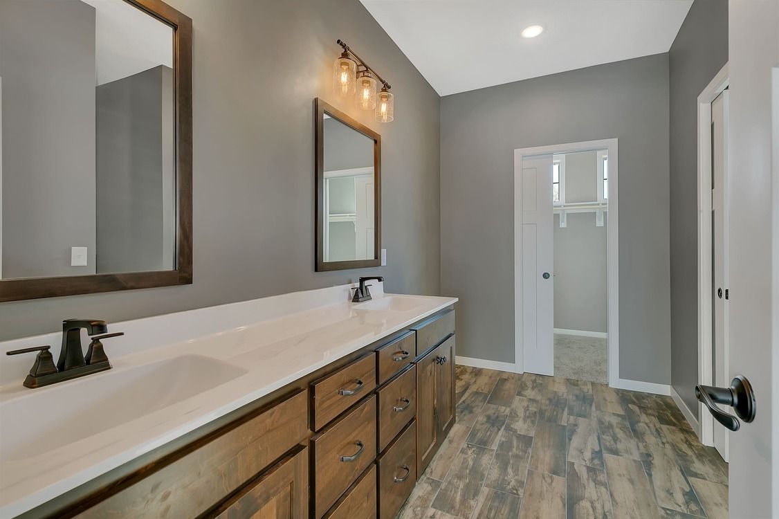 A bathroom with two sinks and two mirrors.