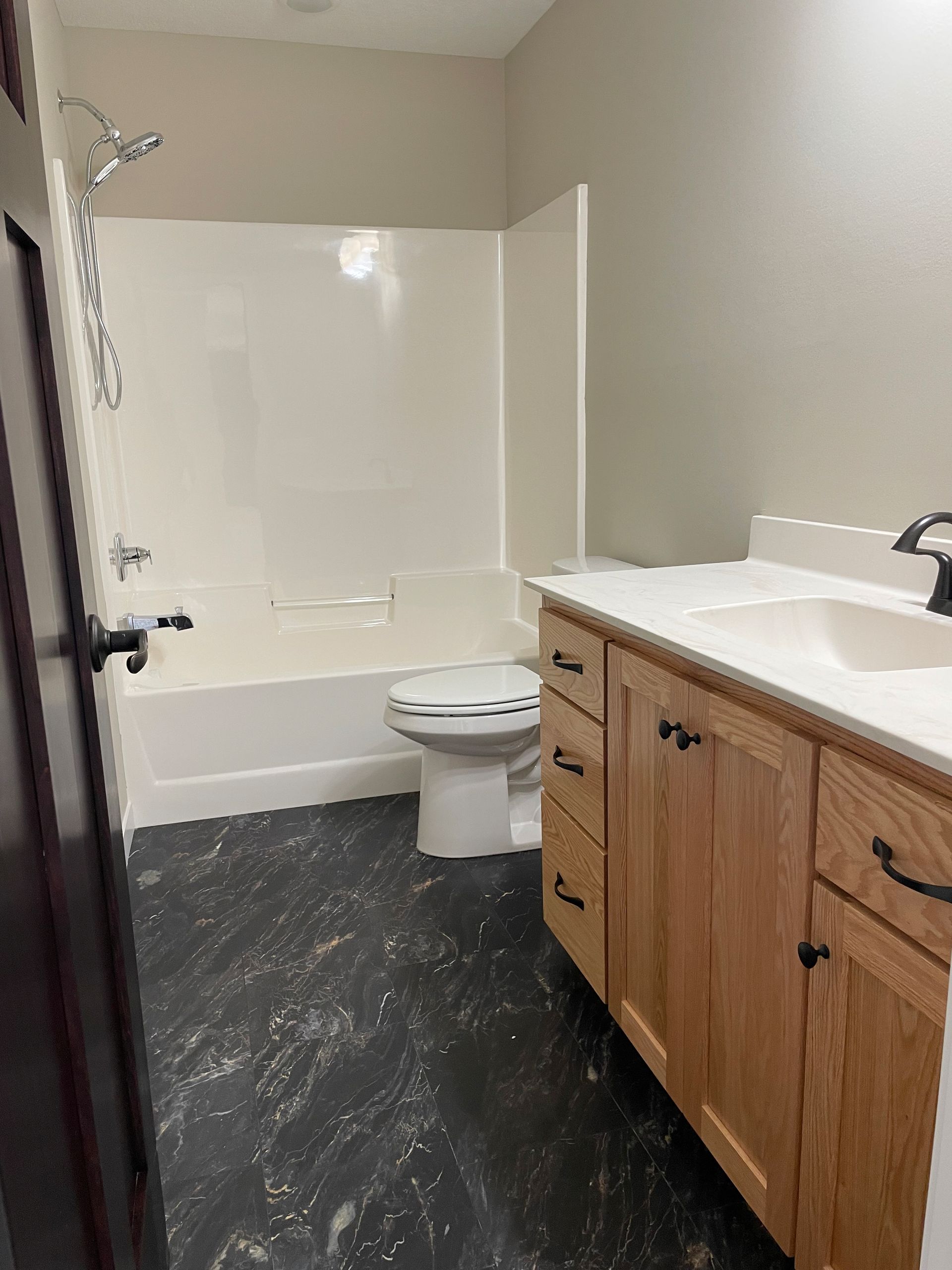 A bathroom with a toilet , sink , bathtub and shower.
