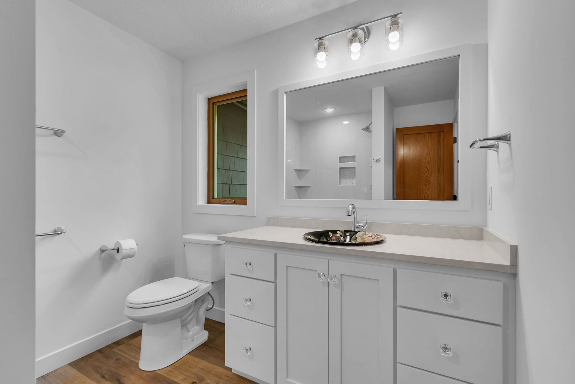 A bathroom with a toilet , sink and mirror.