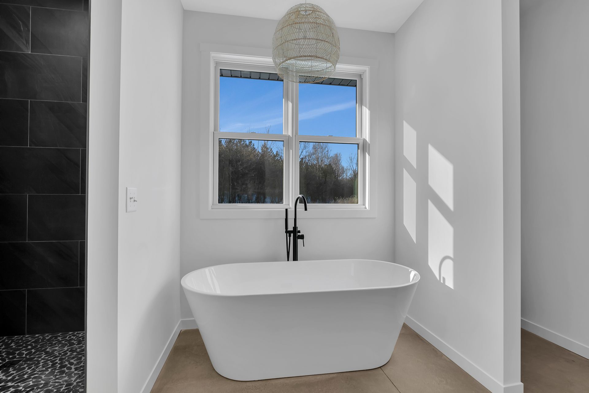 A bathroom with a bathtub and a window.