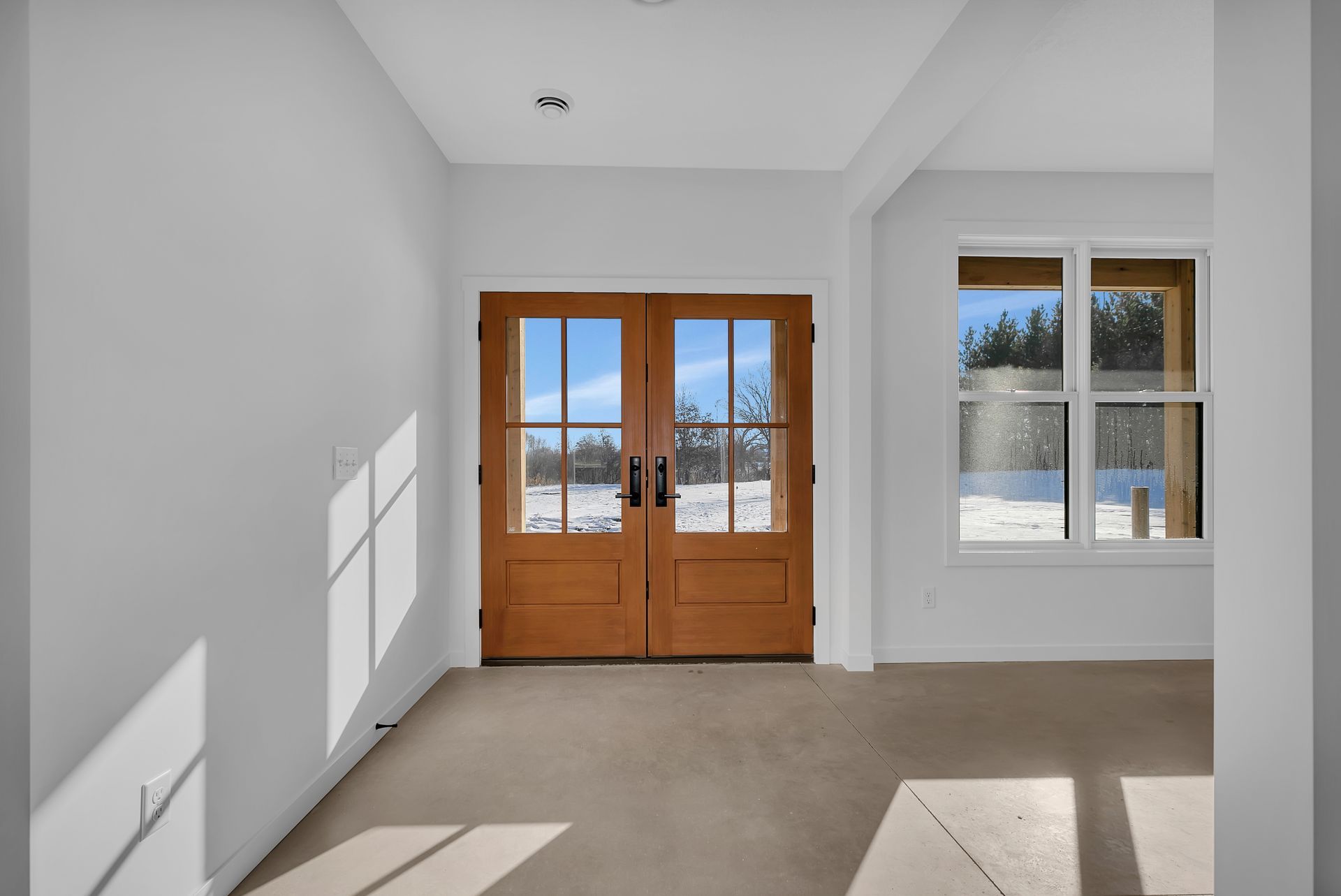 An empty room with a wooden door and a window