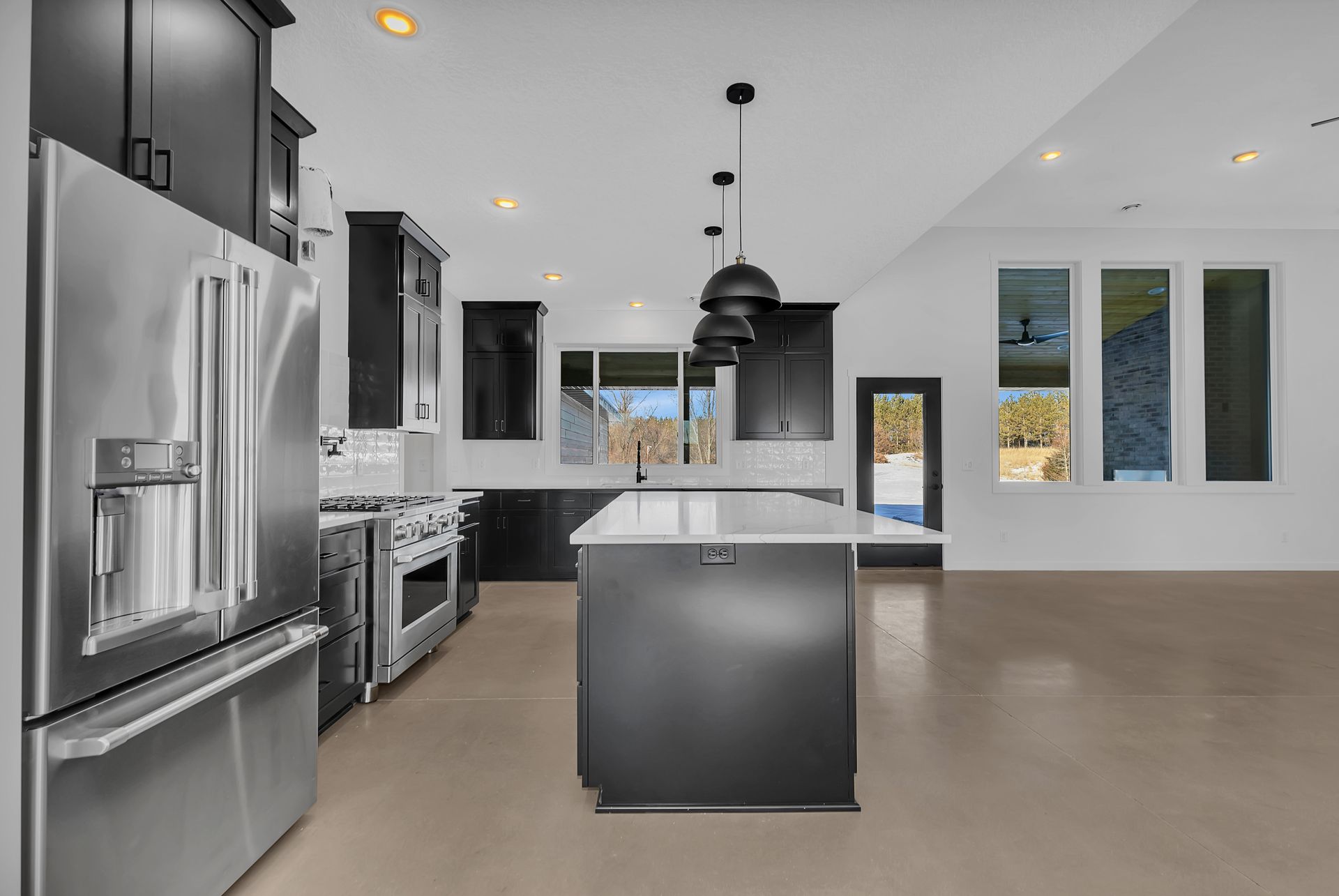 A kitchen with stainless steel appliances and a large island.
