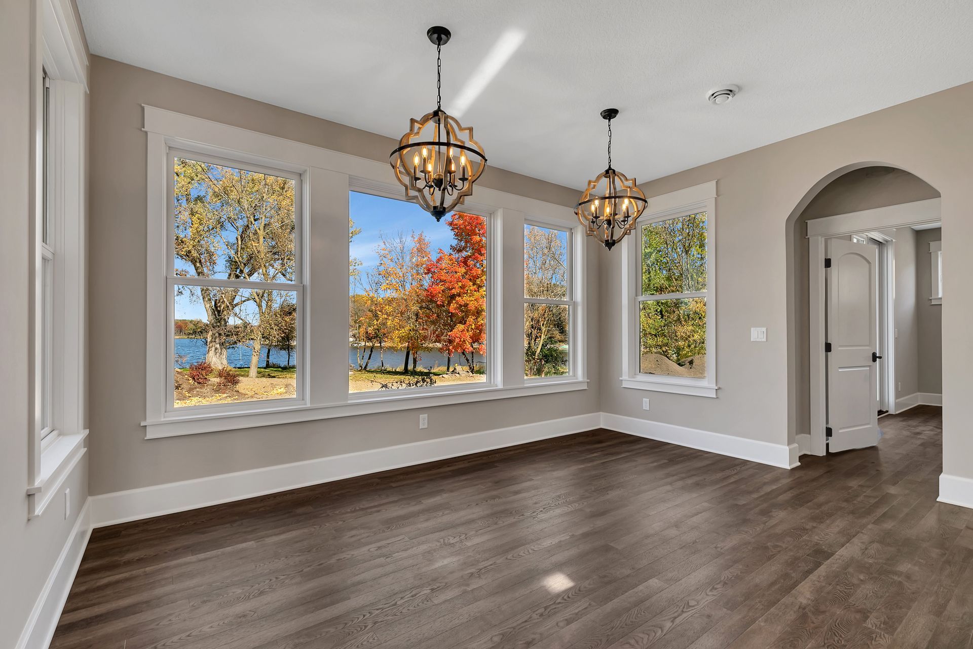An empty room with a lot of windows and a view of a lake.